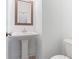 Well-lit powder room featuring a pedestal sink, framed mirror, and modern fixtures at 1309 Bennett Creek Ovlk, Suwanee, GA 30024