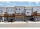 Exterior shot of newly constructed three-story townhomes each with a private deck and attached garage at 1309 Bennett Creek Ovlk, Suwanee, GA 30024