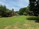 Well-maintained backyard with a large grassy area, mature trees, and a wooden deck perfect for relaxation at 2139 Bramlett Nw Pl, Marietta, GA 30064
