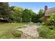 Stone patio surrounded by manicured landscaping features a small dining table and overlooks the tranquil backyard at 2139 Bramlett Nw Pl, Marietta, GA 30064