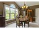 Bright dining room with a large window offering outdoor views and an elegant chandelier over a wooden table at 2139 Bramlett Nw Pl, Marietta, GA 30064