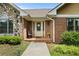 Inviting front porch with brick flooring, a chair, decorative flowers, and a storm door with glass inserts at 2139 Bramlett Nw Pl, Marietta, GA 30064