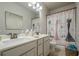 Bathroom with a double sink vanity, framed mirror and a shower with a curtain at 3715 Bridges Ct, Cumming, GA 30040