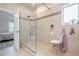 Tiled shower with glass partition, bench, and adjacent bedroom view at 3715 Bridges Ct, Cumming, GA 30040