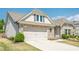 Lovely home featuring neutral siding, a two-car garage, stone details, and manicured landscaping at 3715 Bridges Ct, Cumming, GA 30040