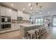 Bright open kitchen featuring an island with seating, stainless steel appliances, and pendant lighting at 3715 Bridges Ct, Cumming, GA 30040