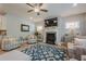 Cozy living room with fireplace, bright windows, ceiling fan and open access to kitchen at 3715 Bridges Ct, Cumming, GA 30040