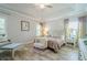 Inviting primary bedroom with tray ceiling, large windows, sitting area, and natural light at 3715 Bridges Ct, Cumming, GA 30040