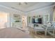 Spacious primary bedroom features tray ceilings, an entertainment center, and a seating area at 3715 Bridges Ct, Cumming, GA 30040