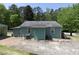 View of the home's backyard featuring a concrete patio, lush grass, and detached garage at 6296 Longino Drive, Union City, GA 30291