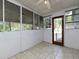 Bright sunroom with white walls and tile floors featuring screened windows and access to outside at 6296 Longino Drive, Union City, GA 30291