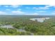 Stunning aerial view of the lake surrounded by a lush green forest under a bright blue sky with scattered clouds at 7370 N Mitchell Ct, Villa Rica, GA 30180