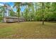 Expansive backyard featuring a home with a large deck, perfect for enjoying the private, wooded surroundings at 7370 N Mitchell Ct, Villa Rica, GA 30180