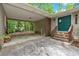 Attached carport and front entrance with stone steps, wood railings, and a green front door at 7370 N Mitchell Ct, Villa Rica, GA 30180