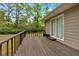Exterior view of a home's wooden deck with a neutral siding, overlooking the lush, green backyard with mature trees at 7370 N Mitchell Ct, Villa Rica, GA 30180