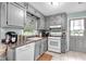 Kitchen features ample countertop space, gray cabinetry, white appliances and tile flooring at 7370 N Mitchell Ct, Villa Rica, GA 30180