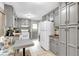 Kitchen features gray cabinetry, breakfast nook, white appliances and tile flooring at 7370 N Mitchell Ct, Villa Rica, GA 30180