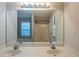 Bathroom featuring a double sink vanity, large mirror with lighting, and a view into the shower/tub area at 107 Providence Run, Dallas, GA 30157