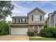 Charming two-story home featuring a front-facing garage, a covered entryway, and manicured landscaping at 107 Providence Run, Dallas, GA 30157