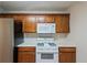 Kitchen featuring wooden cabinets, white appliances, and neutral countertops, offering a clean and functional space at 107 Providence Run, Dallas, GA 30157