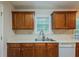 Kitchen showcasing wooden cabinets, a stainless steel sink, and white countertops, complemented by an under-counter dishwasher at 107 Providence Run, Dallas, GA 30157