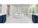 Spa-like bathroom featuring a soaking tub, dual vanities, and stylish marble flooring at 3470 Austin Michael Ln, Cumming, GA 30028