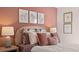 Elegant bedroom featuring a soft pink color palette, plush pillows, and stylish wall art creating a serene retreat at 358 Friendship Oak Way, Hampton, GA 30228