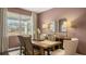 Neutral dining room with a wooden table set, natural light from the window, and modern decor accents at 358 Friendship Oak Way, Hampton, GA 30228