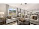 Bright living area featuring gray sofas, modern decor, and an open layout to the kitchen, great for entertaining at 358 Friendship Oak Way, Hampton, GA 30228