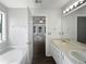 Bright bathroom featuring double vanity, a soaking tub, and access to the living area at 4335 Northwind Dr, Ellenwood, GA 30294
