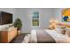 Inviting bedroom with large window, modern decor, wood floors and comfortable bedding, virtually staged for appeal at 4335 Northwind Dr, Ellenwood, GA 30294