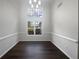 Elegant dining room featuring wainscoting, wood floors, two large windows, and a modern chandelier at 4335 Northwind Dr, Ellenwood, GA 30294