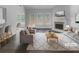 Bright, virtually staged living room with fireplace, hardwood floors, and large windows bringing in natural light at 4335 Northwind Dr, Ellenwood, GA 30294