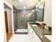 Bathroom with a vanity featuring dual sinks and a glass enclosed shower with dark grey tile and white honeycomb floor at 3205 Brandywine Nw Pl, Marietta, GA 30064