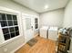 Bright laundry room with washer, dryer, storage shelves, and exterior access at 3205 Brandywine Nw Pl, Marietta, GA 30064