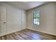Light-filled bedroom showcasing new wood floors and a view to the outdoors at 3959 Wood Path Dr, Stone Mountain, GA 30083