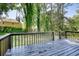 A backyard wooden deck with railing provides a relaxing outdoor space overlooking a lawn and trees at 3959 Wood Path Dr, Stone Mountain, GA 30083