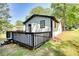 Exterior side view of home with black trimmed windows, a wooden deck and surrounding trees at 3959 Wood Path Dr, Stone Mountain, GA 30083