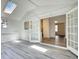 Bright living room with skylight, wood floors, and white French doors to other rooms at 3959 Wood Path Dr, Stone Mountain, GA 30083