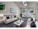 Staged living room with white furniture, modern art and skylight at 3959 Wood Path Dr, Stone Mountain, GA 30083