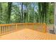 Wooden backyard deck surrounded by lush, mature trees at 798 Brownlee Ln, Lawrenceville, GA 30044