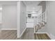 Bright entryway featuring gray walls and vinyl floors, leading to an open staircase and a view of the modern kitchen at 798 Brownlee Ln, Lawrenceville, GA 30044