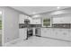 Stylish kitchen with white cabinets, stainless steel appliances, tiled backsplash, and luxury vinyl tile flooring at 798 Brownlee Ln, Lawrenceville, GA 30044