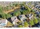 Aerial view showcasing lovely homes nestled among lush trees and a serene pond, offering a peaceful living environment at 3213 Blackley Old Rd, Douglasville, GA 30135