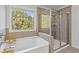 Relaxing bathroom with soaking tub, walk-in shower, and view of natural backyard scenery at 3213 Blackley Old Rd, Douglasville, GA 30135