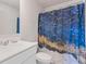 Bathroom with blue marbled shower curtain, single sink, and white toilet at 3213 Blackley Old Rd, Douglasville, GA 30135