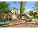 Private backyard featuring a playset, mature trees, upper-level deck with dining area, and a charming yellow home at 3714 Westbrooke Ne Cir, Brookhaven, GA 30319