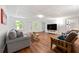 Cozy living room features hardwood floors, a comfortable sofa, and large windows at 3714 Westbrooke Ne Cir, Brookhaven, GA 30319