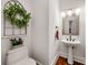 Stylish powder room with pedestal sink, framed mirror and a decorative faux window with greenery at 3714 Westbrooke Ne Cir, Brookhaven, GA 30319