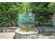 Entrance to John Howell Park with sign, surrounded by greenery and stone accents at 614 Cooledge Ne Ave, Atlanta, GA 30306